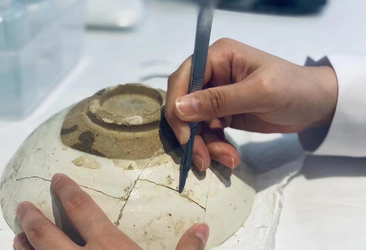 Figure 4: Cleaning during the restoration of a glazed stoneware bowl from the Jin dynasty (1115-1234). Jingdezhen, China, November 22, 2021, by Jia Peng.