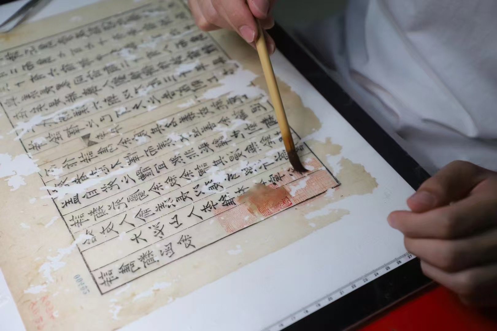 Figure 8: Brush wetting during the restoration of an ancient painting, known as 补水/bǔ shuǐ, as part of the 装潢 process. By He Liang Ren Pucheng.